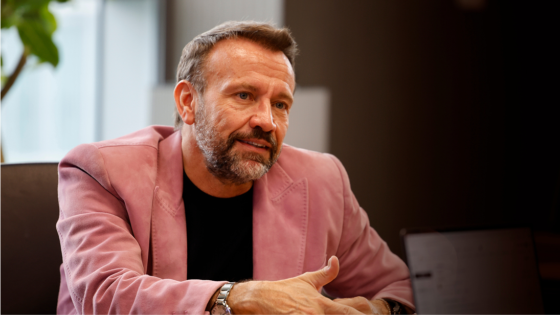 Mauro Porcini speaking while wearing a vintage pink suede jacket.