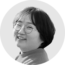 A woman with short hair down to the ears, wearing glasses.