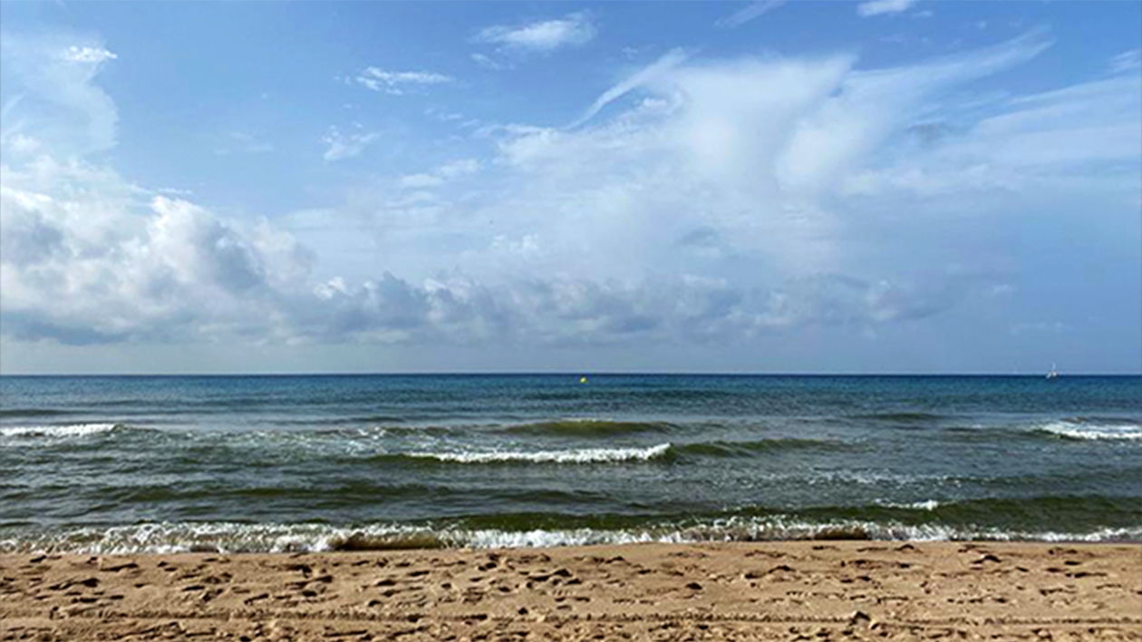 A selfie of a young white woman on the beach in Castelldefels.