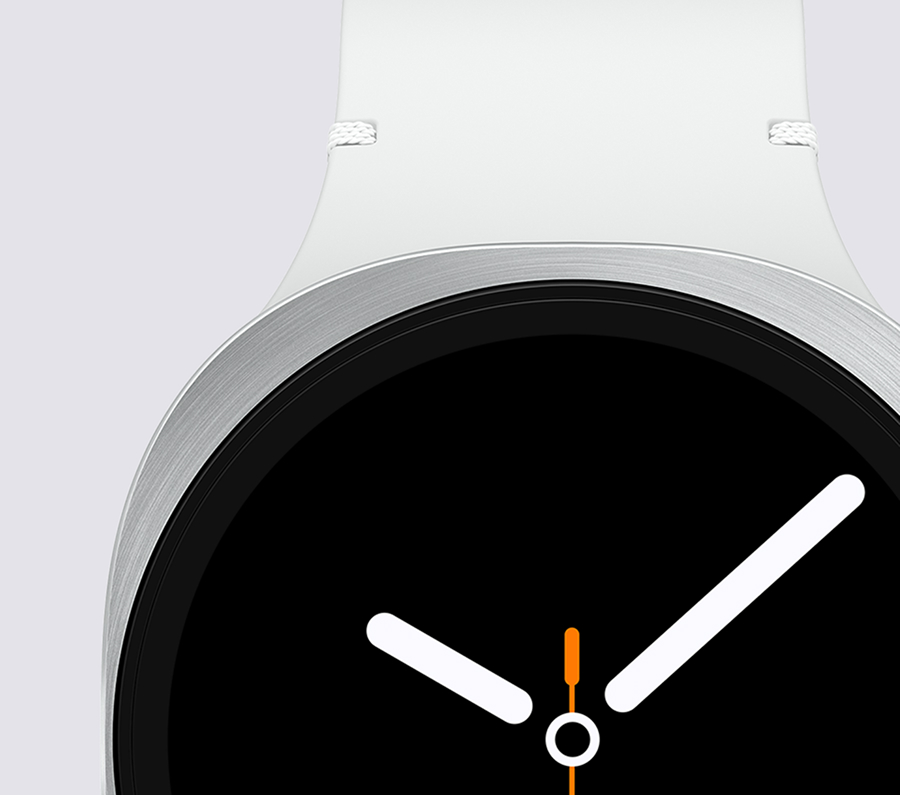 A front close-up of the Galaxy Watch with a white strap and metal bezel, displaying an analog watch UI with white hour and minute hands and an orange second hand on a black screen.