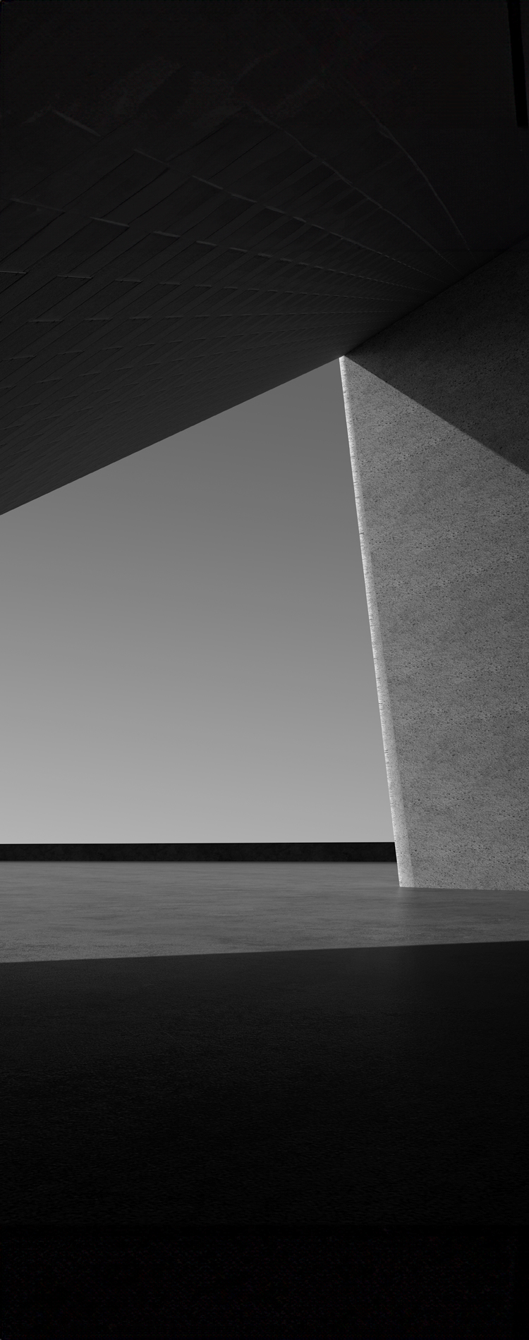 In black and white tones, the shadows cast by the slightly tilted walls and columns create a triangular composition.A space with geometric elements. 