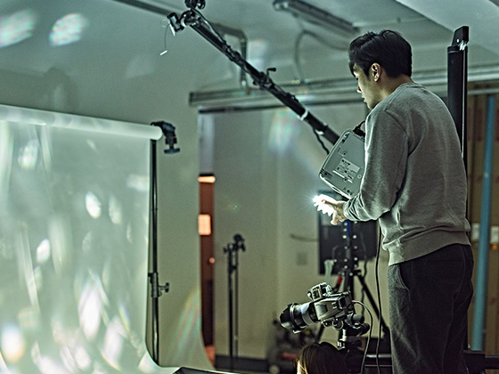 An image shows artist YoungHoon Kim concentrating while creating his work.