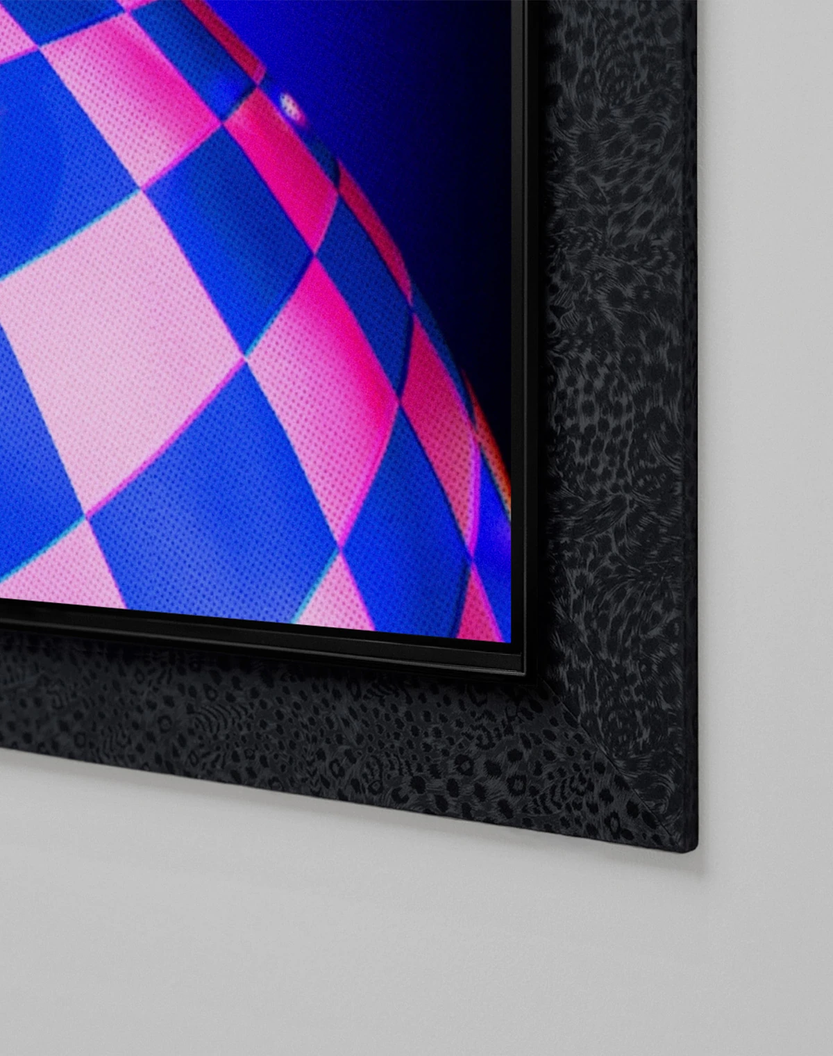 Inside a black patterned frame, The Movingstyle, a movable screen on a white stand, is shown. Its screen depicts red and black curving forms and small creatures on a pink-and-blue checkerboard planet.