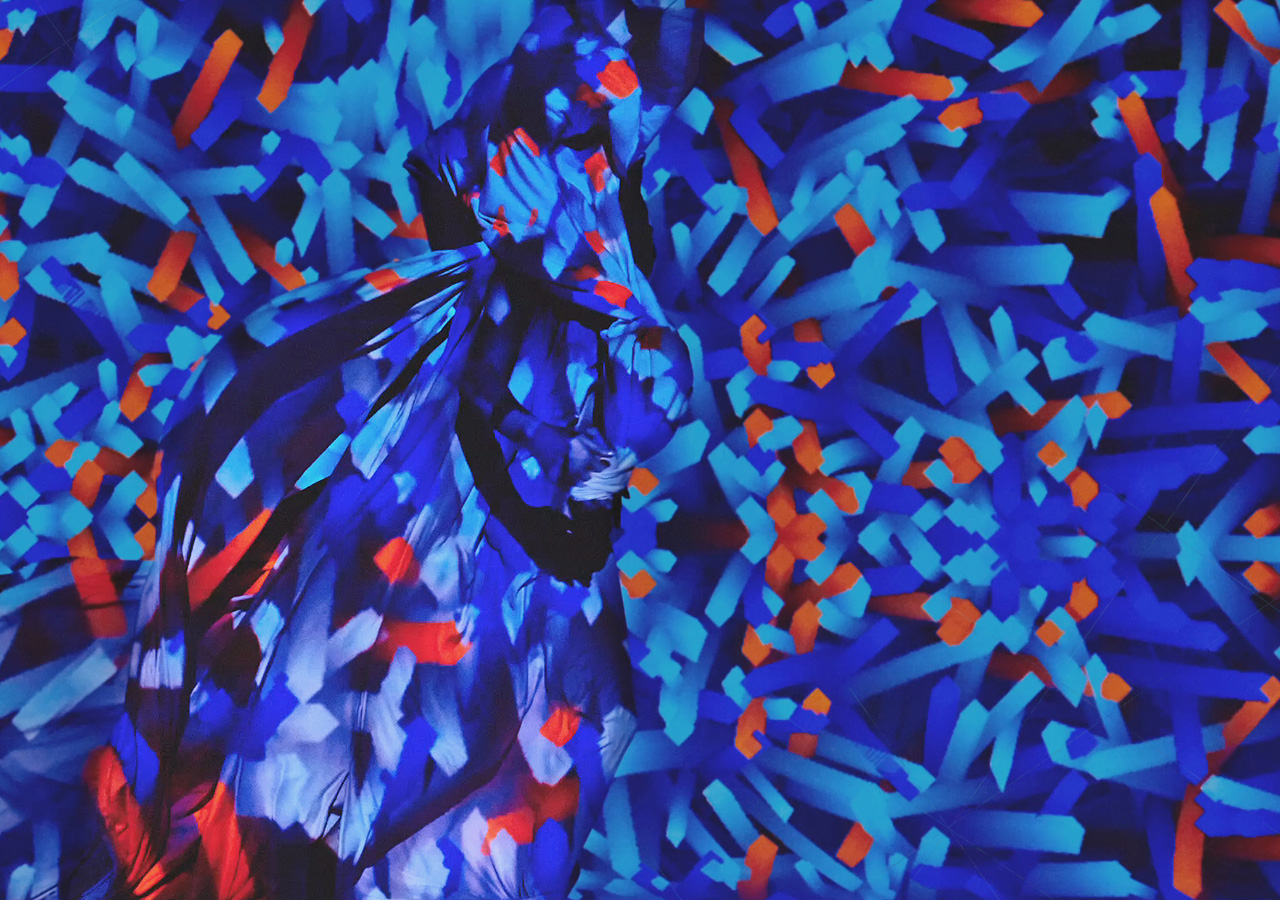 An image shows the model posing as a digital design is projected onto her.