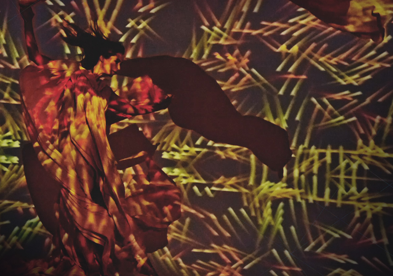 An image shows the model posing as a digital design is projected onto her.