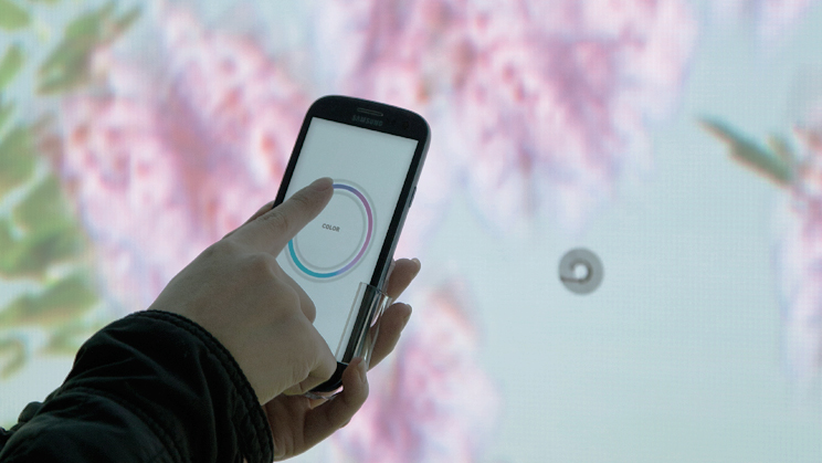 모바일로 랩핑된 벽면을 촬영했을 때의 이미지가 있습니다. 모바일과 벽면의 영상이 서로 반응하여 새로운 장면을 만들어 냅니다.