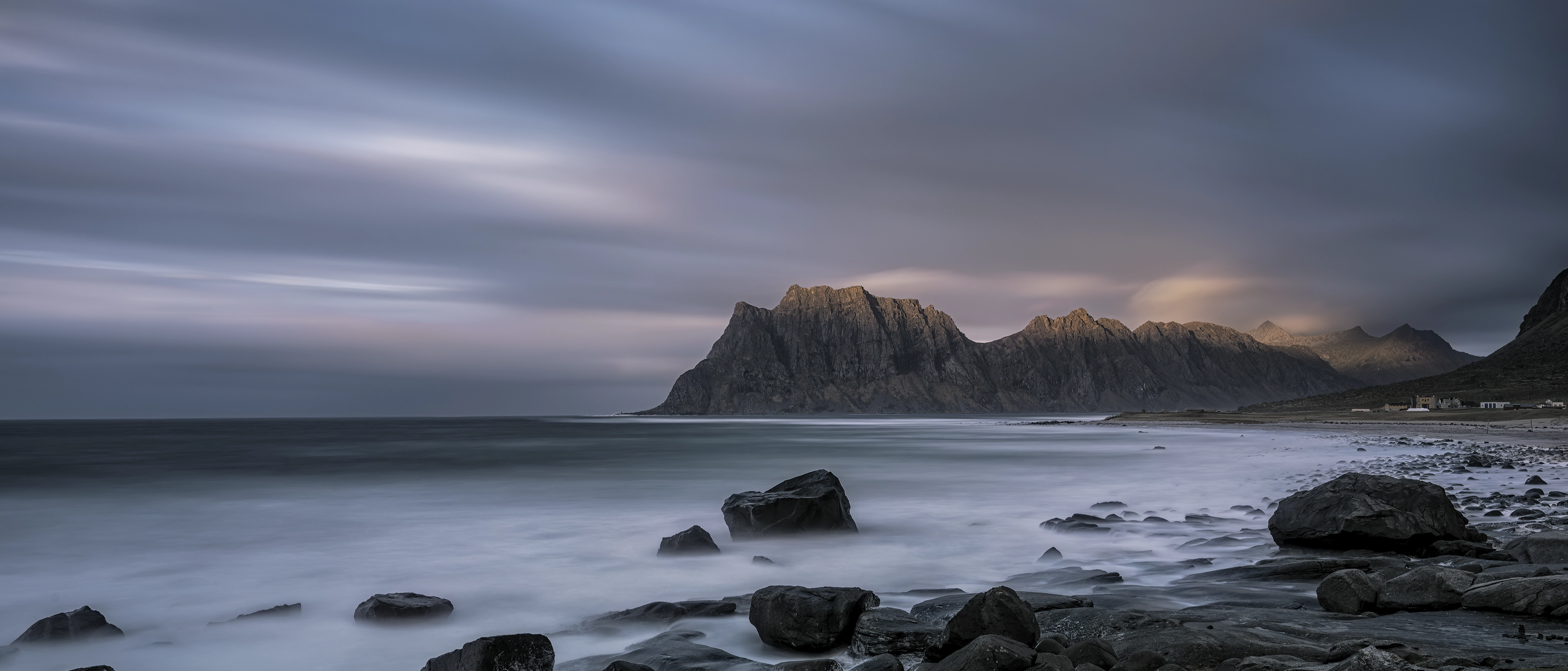 어두운 하늘과 바다, 거대한 돌과 암석 산맥이 보이는 자연 이미지가 점점 확대되는 삼성 XR 인터랙션.